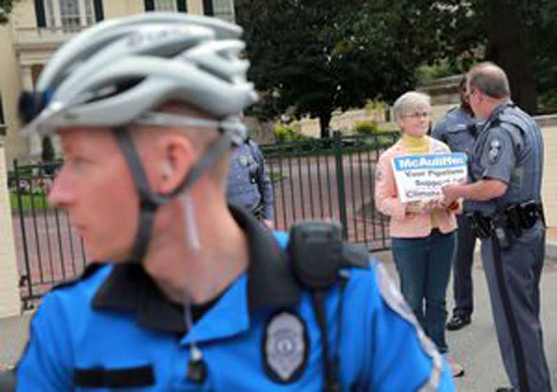A protester is arrested by Virginia Capitol Police during a rally against pipelines, coal ash and climate change in front of the Executive Mansion.